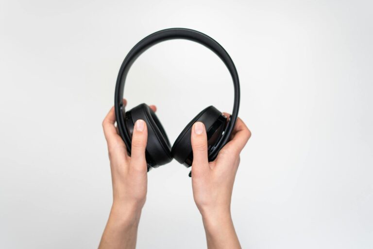 Person Holding Black Wireless Headphones